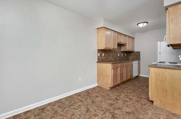 Wichita apartment for rent - a kitchen with wooden cabinets and a stove and a refrigerator