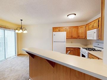 Rochester townhouse for rent - a kitchen with a counter top and a white refrigerator