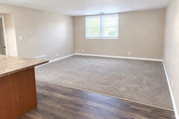Bloomington apartment for rent - A room with a brown carpet and a wooden cabinet.