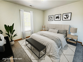 Kalamazoo apartment for rent - A bedroom with a large bed, a bench, and three framed pictures on the wall.