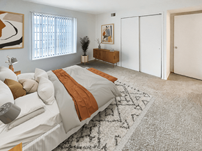 Waterford apartment for rent - a bedroom with white walls and a white bed with an orange blanket