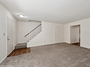 Fairfield townhouse for rent - a renovated living room with carpet and a staircase