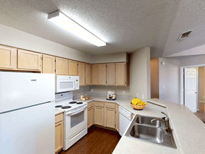 Lubbock apartment for rent - a kitchen with white appliances and wooden cabinets