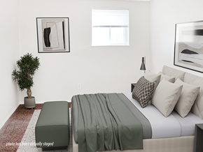 Reynoldsburg townhouse for rent - A bedroom with a bed, a bench, and a potted plant.