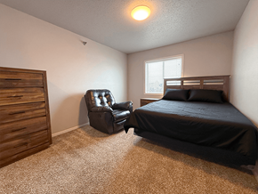Williston apartment for rent - A bedroom with a bed, chair, and dresser.