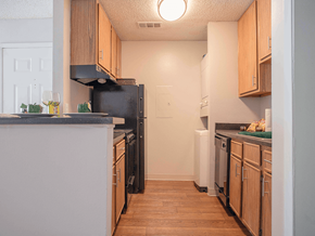Little Rock apartment for rent - a kitchen with wooden cabinets and a black refrigerator