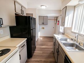 Wichita townhouse for rent - A kitchen with a black refrigerator and white countertops.