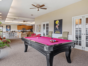 East Lansing apartment for rent - A pool table in a room with a ceiling fan.