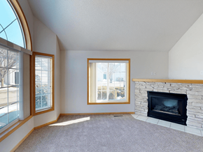 Rochester townhouse for rent - A living room with a fireplace and a large window.