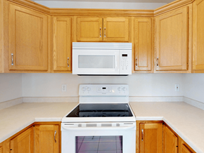 Rochester townhouse for rent - A kitchen with wooden cabinets and white appliances.