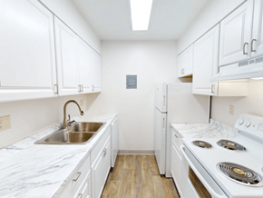 Canon City apartment for rent - A kitchen with white cabinets and a white stove top oven.