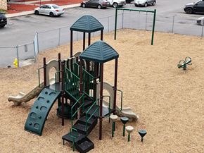 Minneapolis apartment for rent - A playground with a green slide and a green roofed structure.