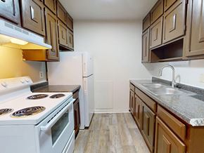 Minneapolis apartment for rent - A kitchen with a white stove and brown cabinets.