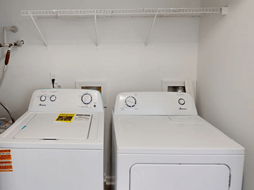 Fayetteville apartment for rent - Two white front loading washing machines in a laundry room.