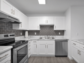 Fayetteville apartment for rent - Apartment kitchen with white cabinets and a black stove top oven