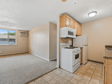 Rapid City apartment for rent - A kitchen with a white stove and refrigerator.