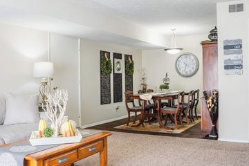 Omaha apartment for rent - A living room with a couch, a coffee table, and a dining table set up.