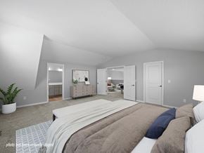 Ashland apartment for rent - A bedroom with a large bed and a plant in the corner.