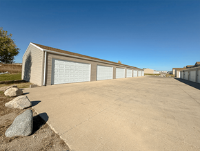 Williston apartment for rent - A long building with a garage door is in the foreground.