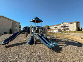 Williston apartment for rent - A playground with a blue slide and a wooden structure.