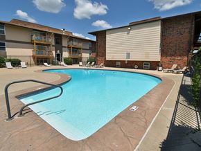 Wichita apartment for rent - a swimming pool with a building in the background