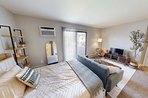 Kentwood apartment for rent - A well-lit bedroom with a large bed and a television.