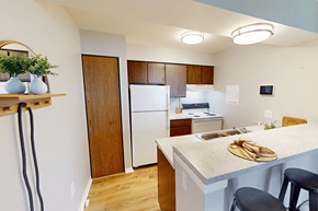 Kentwood apartment for rent - A kitchen with a white refrigerator and wooden cabinets.