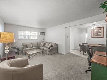 Niles apartment for rent - A living room with a grey couch and a brown armchair.