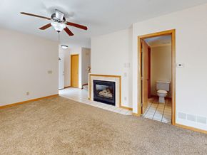 Rochester townhouse for rent - A living room with a fireplace and a ceiling fan.