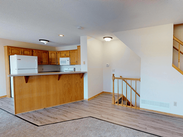 Rochester townhouse for rent - A kitchen with wooden cabinets and a white refrigerator.