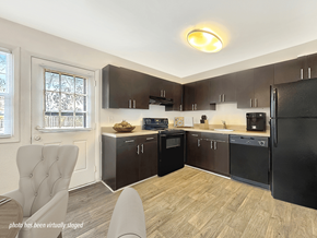 Wilmington apartment for rent - A kitchen with black appliances and wooden floors.