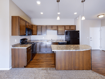Williston apartment for rent - A kitchen with wooden cabinets and a black refrigerator.