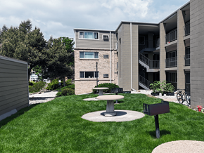 Golden apartment for rent - A modern building with a green lawn in front.