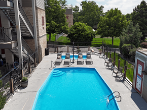 Golden apartment for rent - A pool surrounded by chairs and trees.