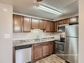 Golden apartment for rent - A kitchen with brown cabinets and stainless steel appliances.