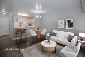 Grand Rapids apartment for rent - A living room with a white couch, a coffee table, and a dining table with chairs.