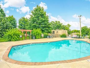 Overland Park apartment for rent - a swimming pool with trees and a building in the background