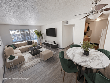 Rochester townhouse for rent - A living room with a white ceiling fan and a white marble table surrounded by green chairs.