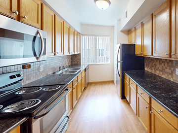 Rochester townhouse for rent - A kitchen with wooden cabinets and a black counter top.