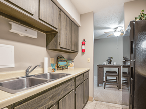 Omaha townhouse for rent - a kitchen with a sink and a refrigerator and a table with a chair