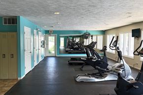 Omaha apartment for rent - A gym with exercise equipment and a blue wall.