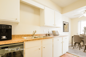Omaha apartment for rent - A kitchen with white cabinets and a black microwave.