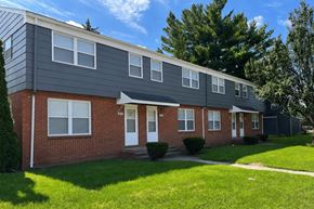Rantoul townhouse for rent - A two-story house with a red brick facade and a grey roof.