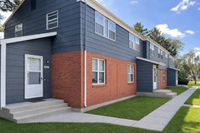 Rantoul townhouse for rent - A modern two-story house with a blue exterior and a red brick section.