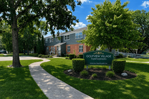 Rantoul townhouse for rent - A sign for Golfview Village Townhomes is in the foreground of a well kept lawn.