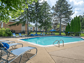 East Lansing townhouse for rent - A pool surrounded by trees and chairs.