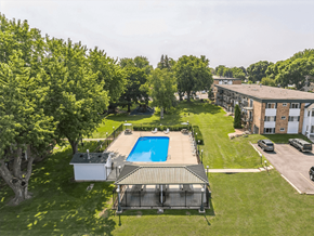 Rochester apartment for rent - an aerial view of a swimming pool in the middle of a yard with a building