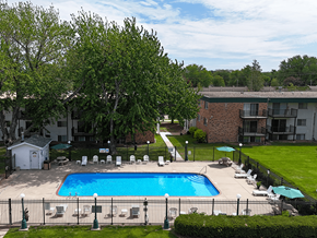 Rochester apartment for rent - A pool surrounded by lawn chairs and trees.