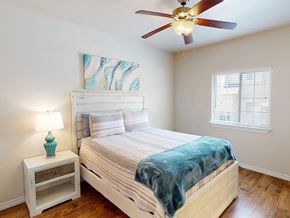 Hobbs apartment for rent - A bedroom with a bed, a nightstand, and a ceiling fan.