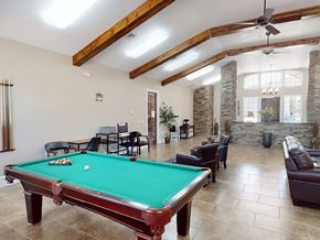 Hobbs apartment for rent - A pool table is in the middle of a room with a couch and chairs.